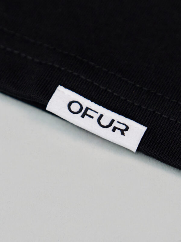 Close up of the OFUR hem label on the black T-Shirt