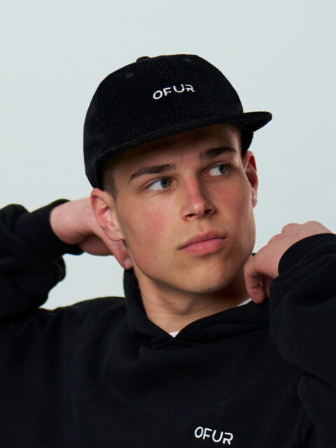 Model wearing the OFUR cap in combination with the white OFUR shirt and the black OFUR hoodie