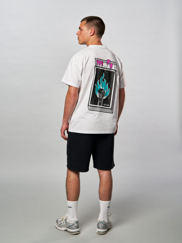 Model wearing the white fire punch T-Shirt in combination with a short and white embroidered socks
