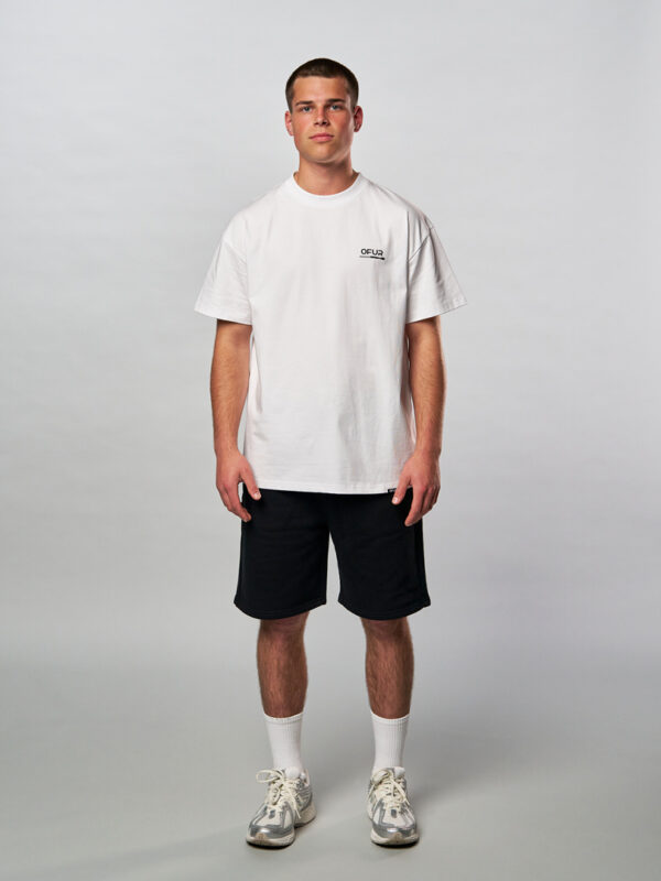 Model seen from the front wearing the white fire punch T-Shirt in combination with the white embroidered socks