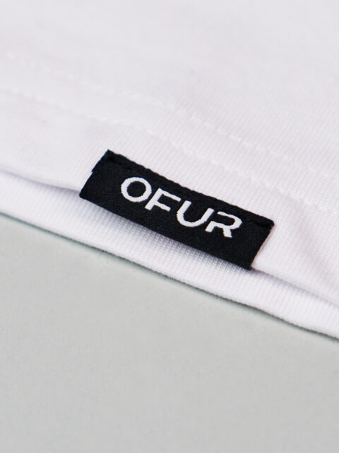 Close up of the OFUR hem label on the white T-Shirt