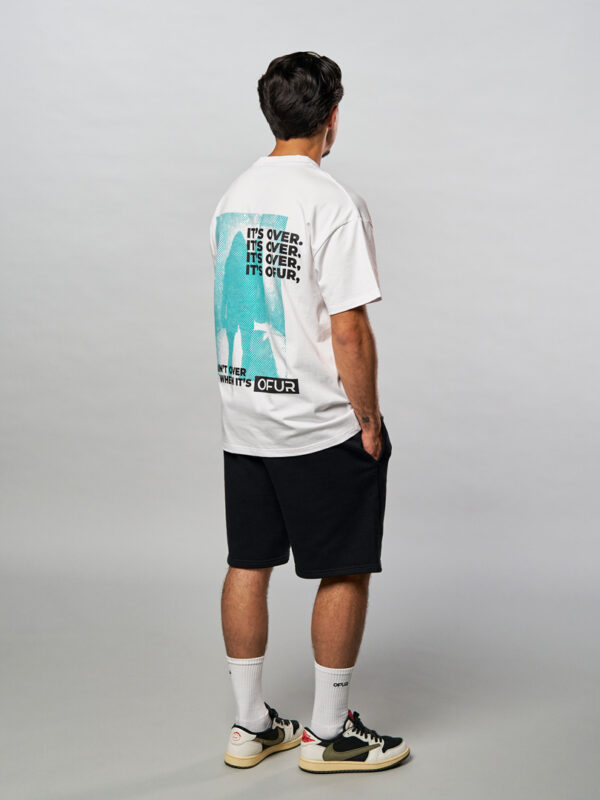 Model seen from the back wearing the white it ain't over T-Shirt in combination with the white embroidered socks