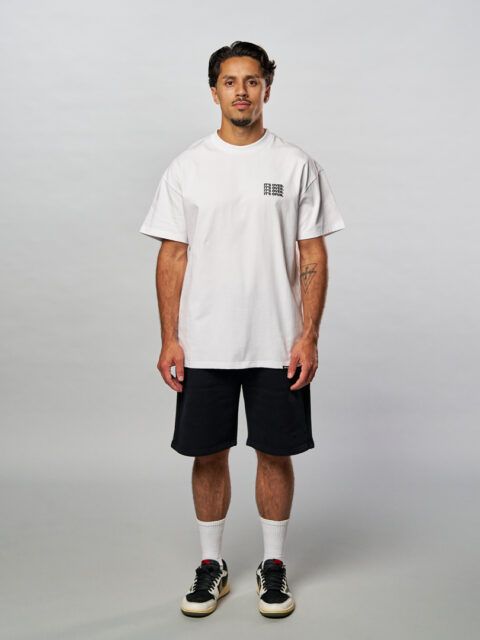 Model seen from the front wearing the white it ain't over T-Shirt in combination with the white embroidered socks