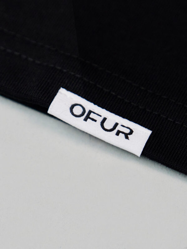 Close up of the OFUR hem label on the black T-Shirt