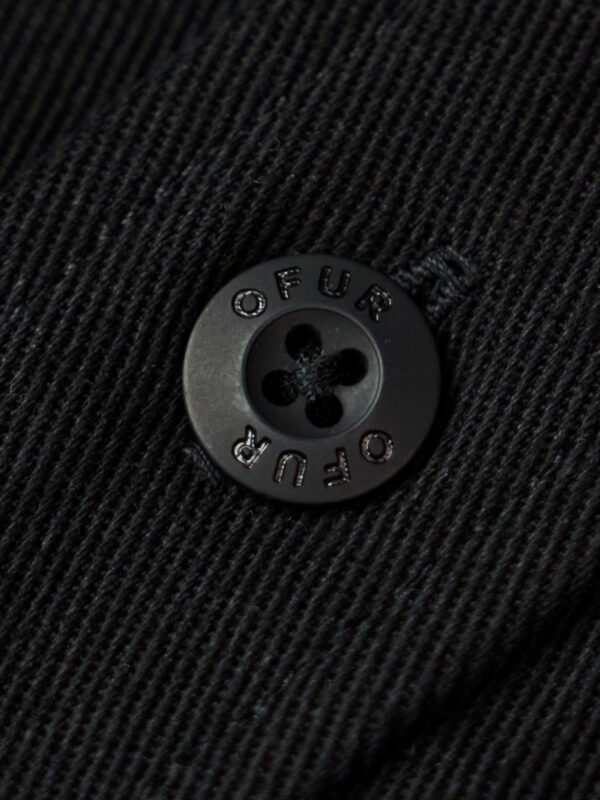 Close up of the black OFUR button on the typo shirt