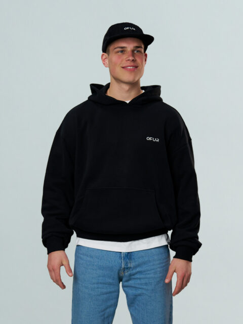 Model is wearing the black OFUR hoodie and the black OFUR cap