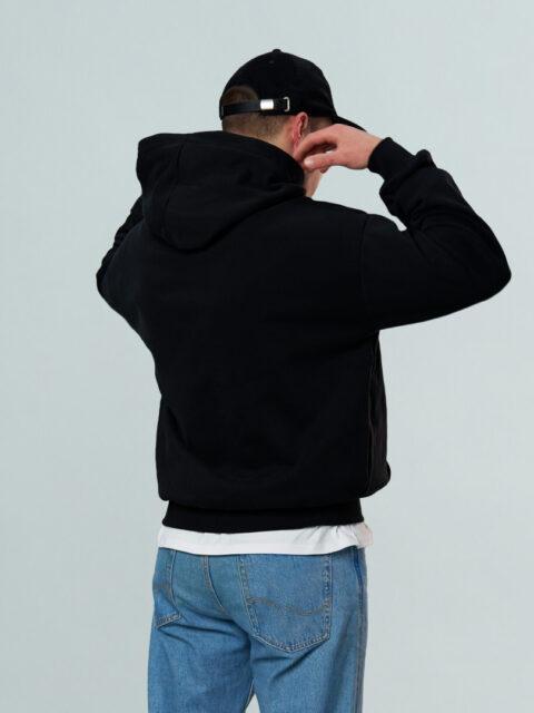 Model wearing a black OFUR hoodie with the black OFUR cap