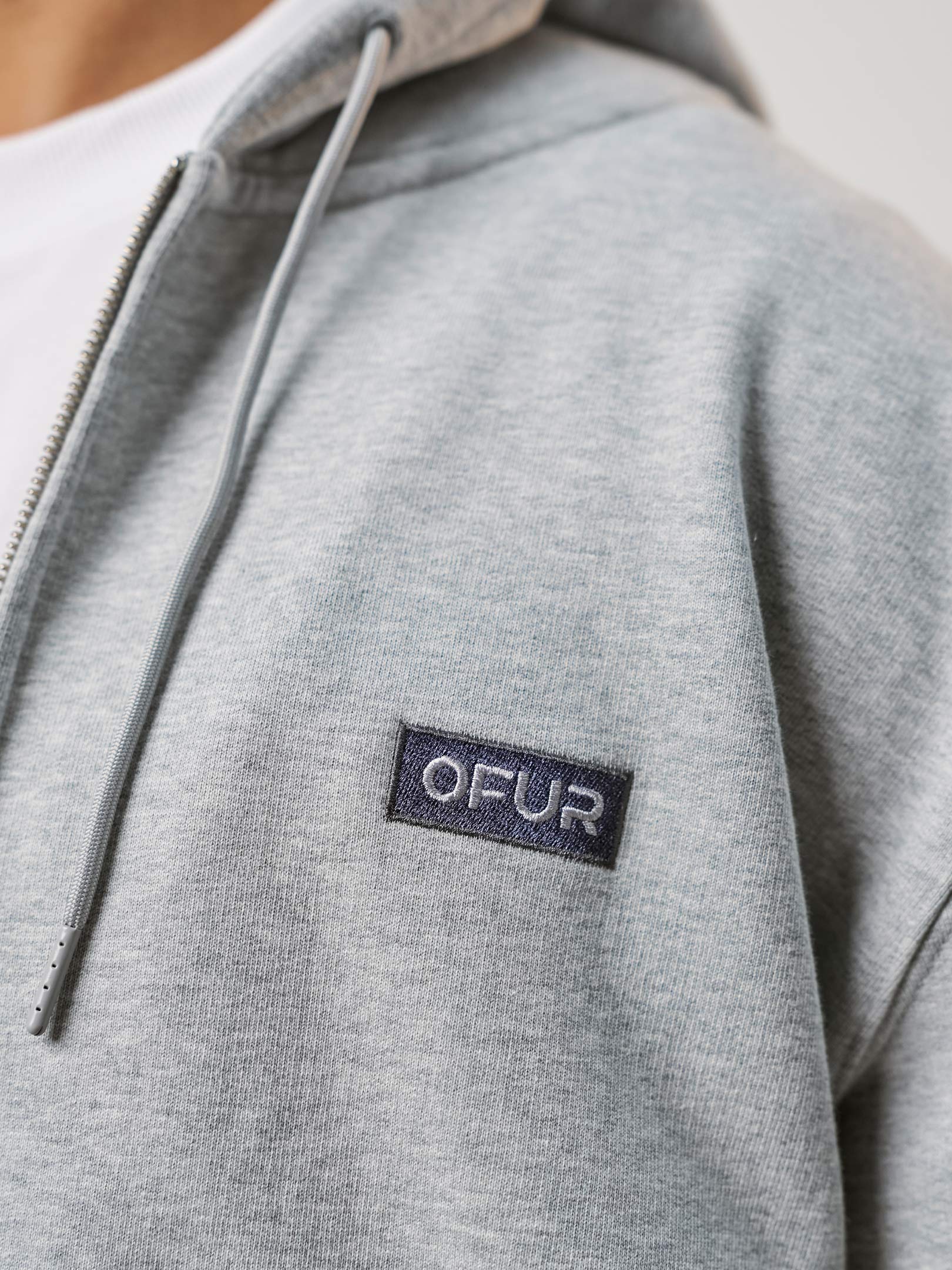 OFUR_FW25_RISE_APPLIQUE_ZIP_HOODIE_CLOSE_UP_FRONT_1